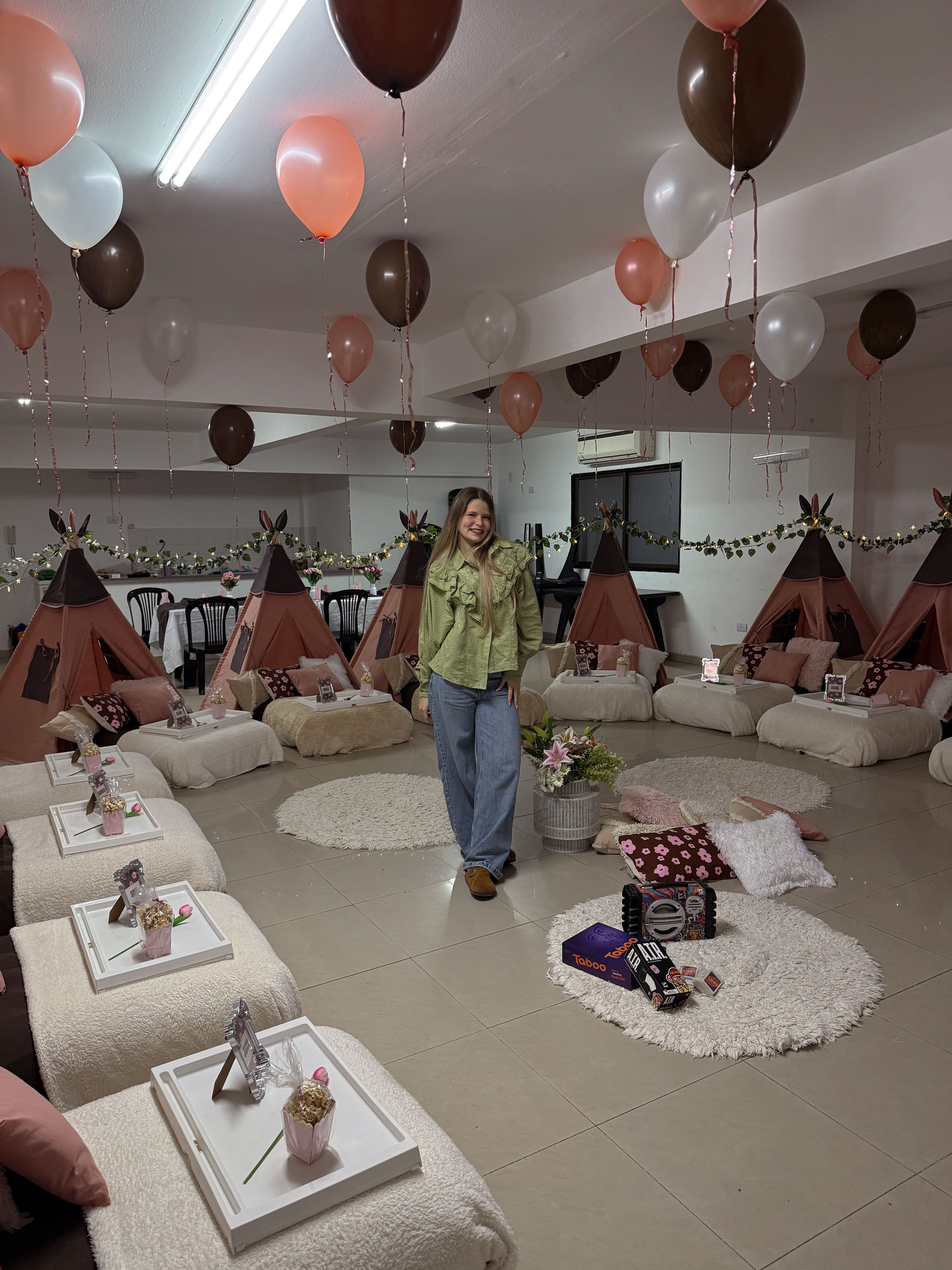 Mica, creadora de Fantasía, en una pijamada con carpas tipi rosa y chocolate, globos y colchones con bandejas.