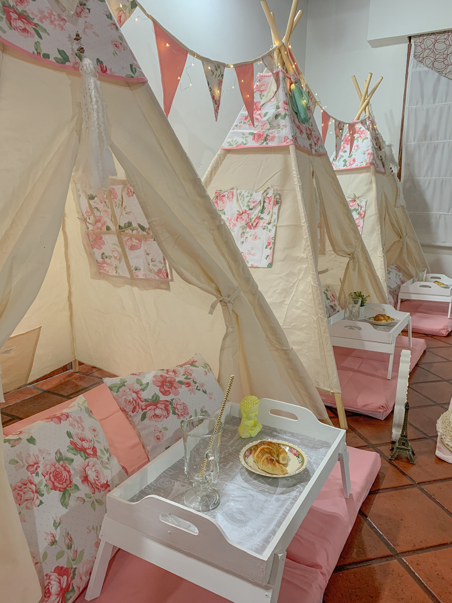 Carpas con colchonetas rosas en diagonal, con banderines, almohadones y bandejas.